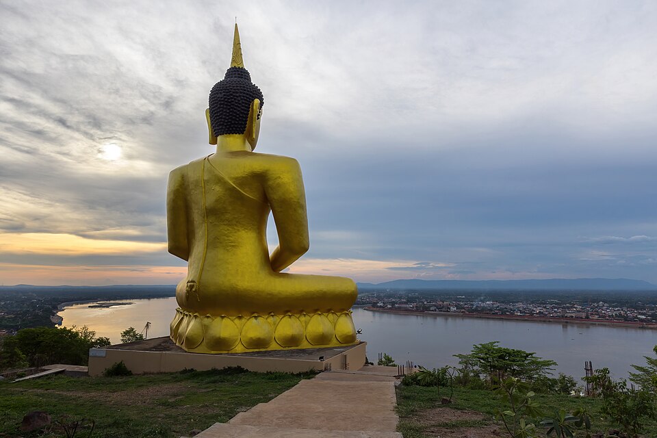 Golden Buddha seen from behind at sunset at Wat Phou Salao temple in Pakse Laos